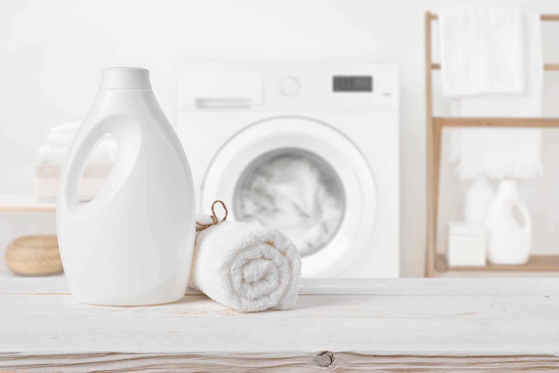 Plain detergent bottle on wood over defocused laundry room interior